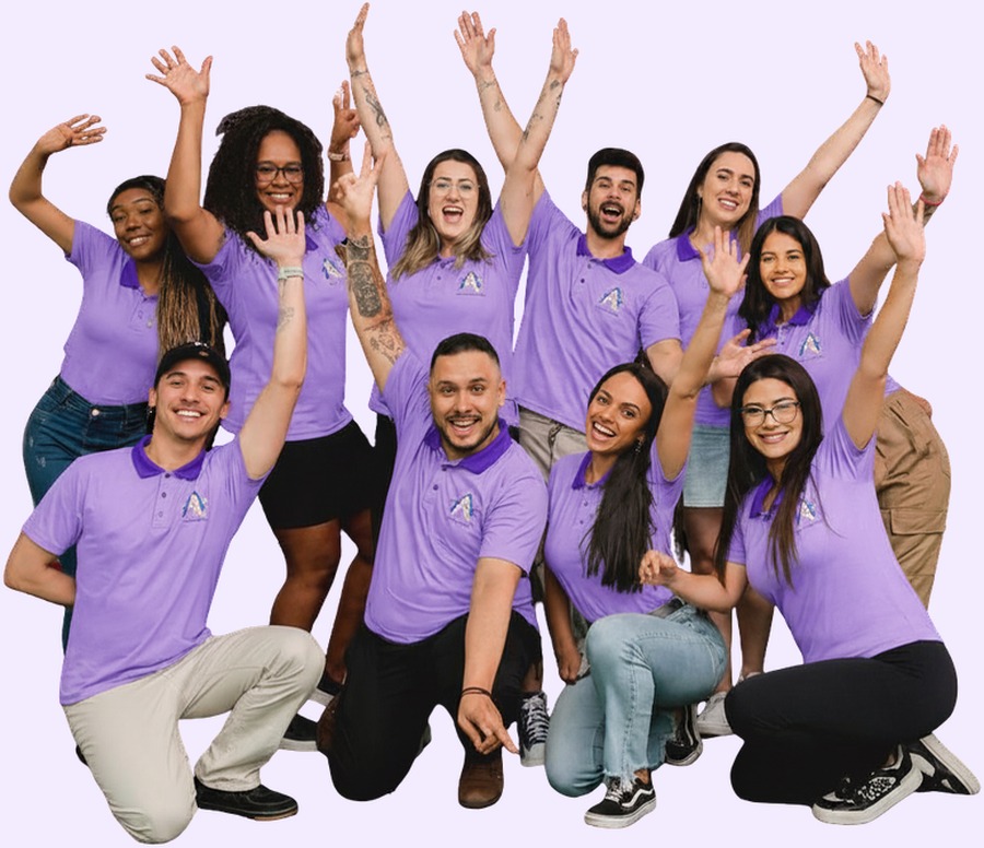 Equipe da Amigos de Eventos de camiseta lilás, com os braços levantados
